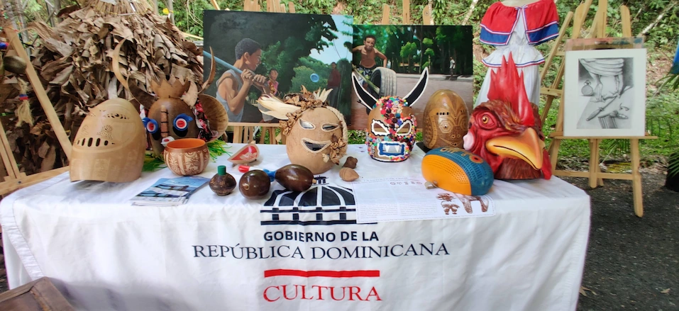 Exposición de artesanías de Cotuí con diversas caretas tradicionales de jíguero pintadas a mano y elementos del Ministerio de Cultura en República Dominicana.