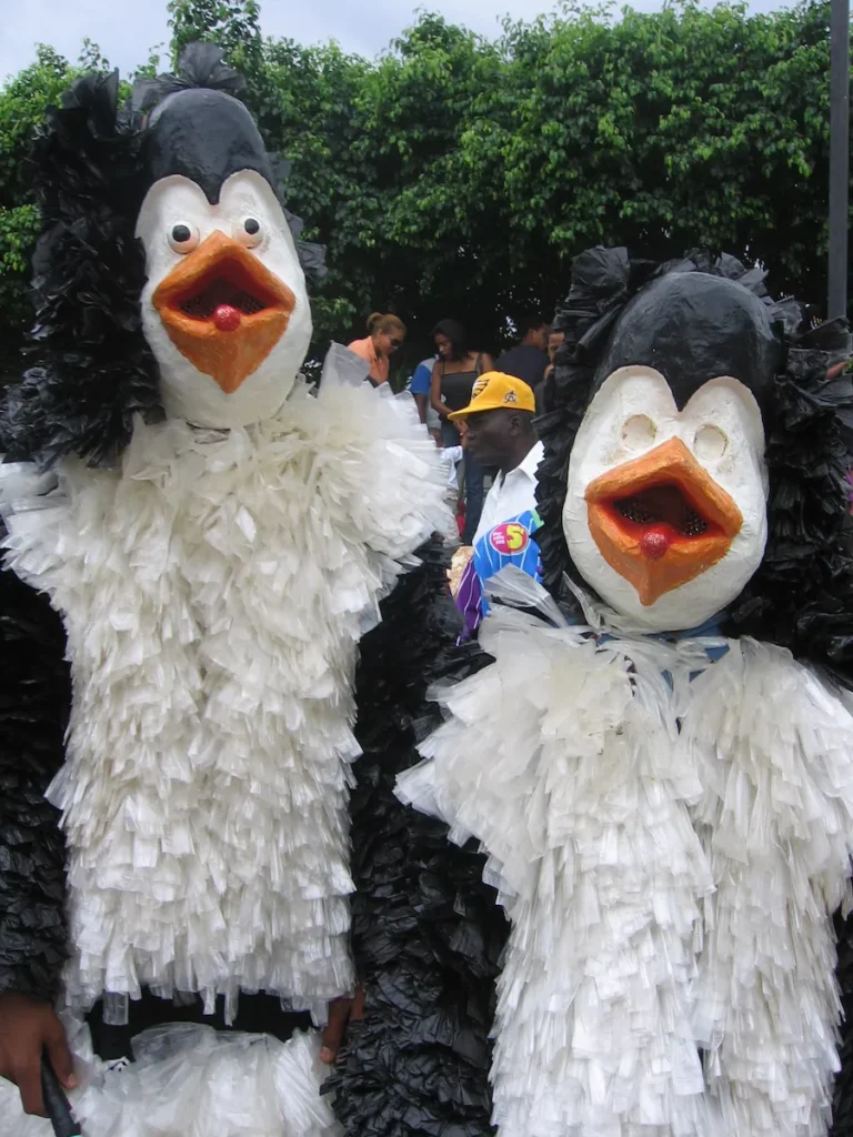 Dos personajes de Los Funduses con disfraces blancos y negros confeccionados con bolsas plásticas en el desfile del Carnaval Cotuisano